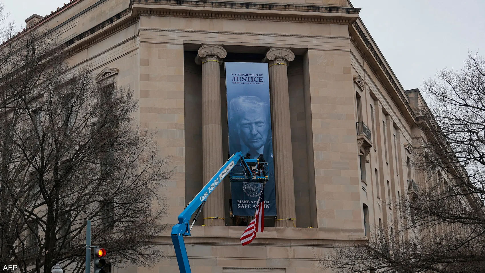 لافتة تحمل صورة ترامب تُرفع على مبنى وزارة العدل في واشنطن