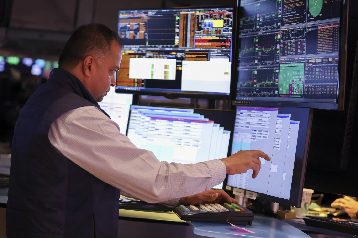 متداول يراقب شاشات تعرض مؤشرات الأسهم في بورصة نيويورك